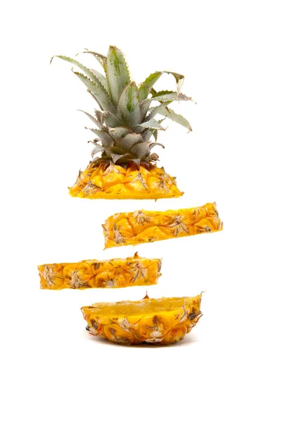 Beyaz arka planda yüzen olgun, lezzetli bebek ananas dilimleri