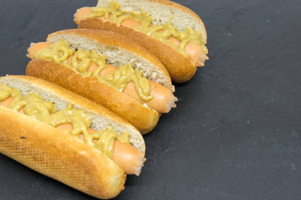 delicious homemade hot dogs on black slate close up photo