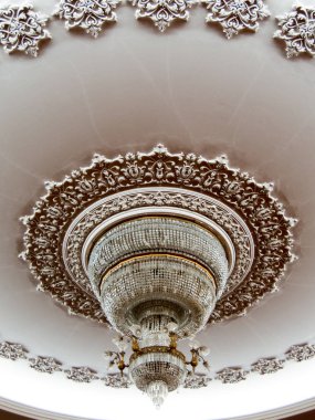 Güzel dekore edilmiş tavanda büyük bir avize.