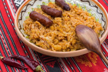 Romanya yemeği turşulu lahana güveci ince sosis ve biberli geleneksel halı.