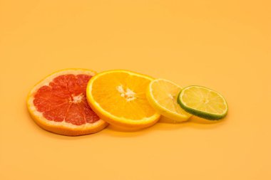 Renkli arkaplan üzerine yerleştirilmiş limon ve greyfurt dilimleri. Fotokopi alanı olan soyut duvar kağıdı.