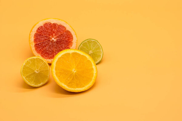 various citrus slices of orange lime lemon and grapefruit arranged on colorful background abstract wallpaper with copy space