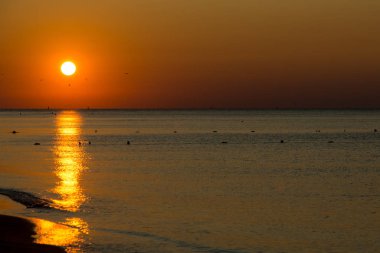 Deniz kenarında sakin bir gün doğumu manzarası