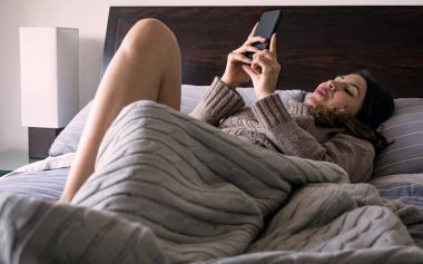 Latin kadın yatak odasında cep telefonu izlemek üçüncü fotoğraf