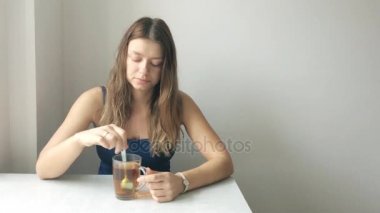 Sarı saçlı makyaj olmadan güzel bir genç kadının portresi Kaşık Çay engeller
