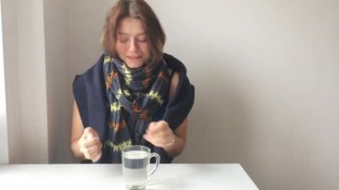 Sarı saçlı bir eşarp ile şirin bir kız portresi. Hasta genç kadın öksürük, yakın çekim