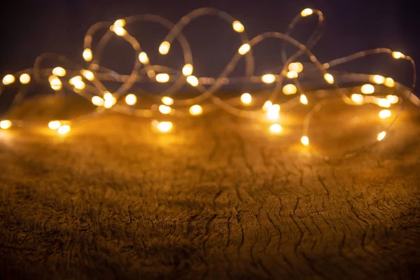 Defocus luzes de Natal sobre fundo de madeira. foco seletivo o — Fotografia de Stock