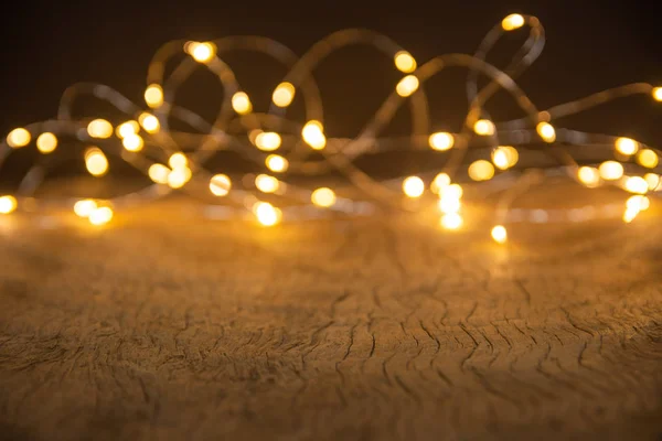 Defocus luzes de Natal sobre fundo de madeira. foco seletivo o — Fotografia de Stock