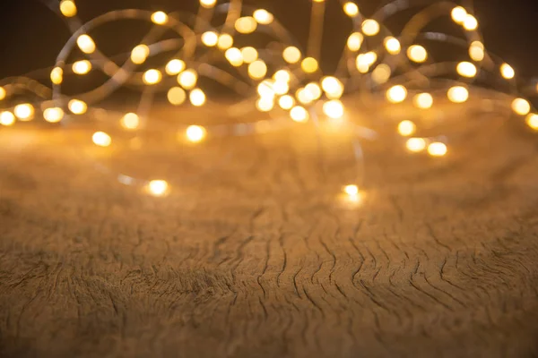 Defocus luzes de Natal sobre fundo de madeira. foco seletivo o — Fotografia de Stock