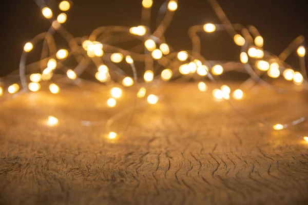 Defocus luzes de Natal sobre fundo de madeira. foco seletivo o — Fotografia de Stock