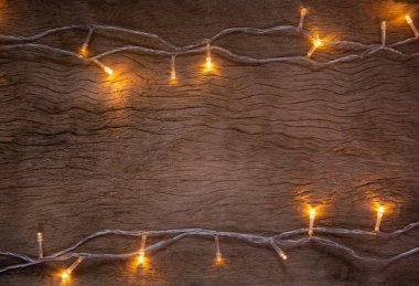 Tahta arka planda Noel ışıkları. Mutlu Noeller.