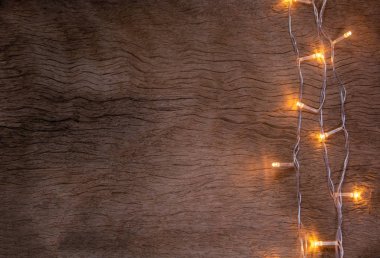 Tahta arka planda Noel ışıkları. Mutlu Noeller.