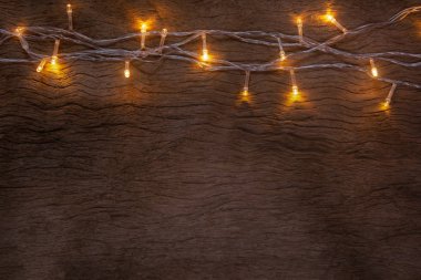 Tahta arka planda Noel ışıkları. Mutlu Noeller.