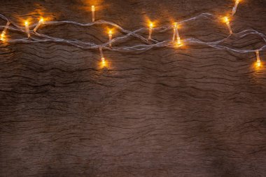 Tahta arka planda Noel ışıkları. Mutlu Noeller.