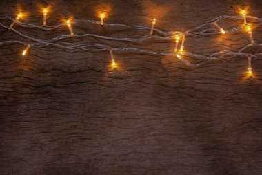 Tahta arka planda Noel ışıkları. Mutlu Noeller.