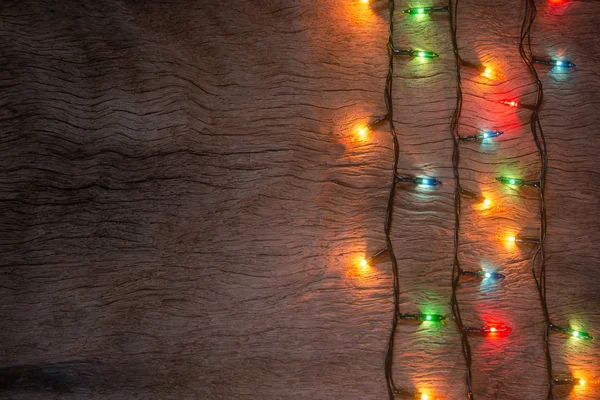 Luzes de Natal no fundo da prancha de madeira. Feliz Natal e — Fotografia de Stock