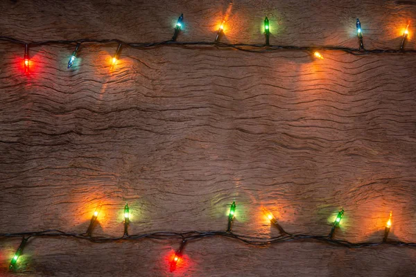 Luzes de Natal no fundo da prancha de madeira. Feliz Natal e — Fotografia de Stock