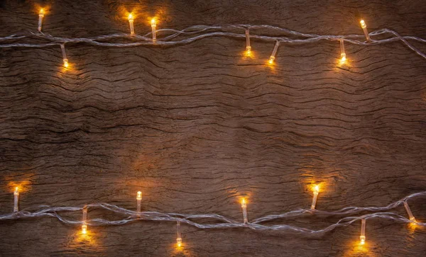 Luzes de Natal no fundo da prancha de madeira. Feliz Natal e — Fotografia de Stock