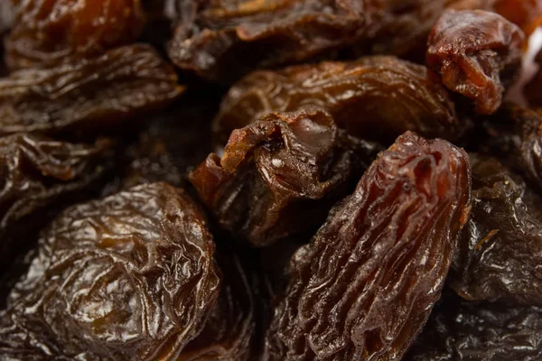 Black dried raisins background. Raisins as background