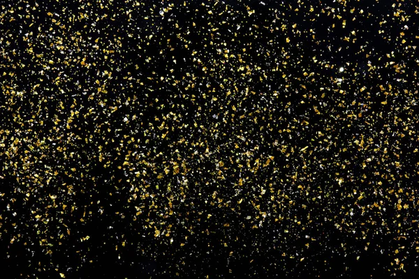 Golden glitter texture on black abstract background — Stok fotoğraf