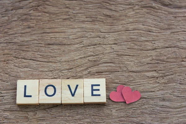Text wooden blocks spelling the word love on wooden background — Stok fotoğraf