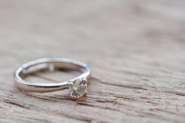 Diamond ring, wedding ring on plank wooden with copy space