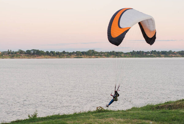 молодая женщина спускается на парашюте к земле Риверсайд
