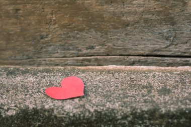 Beton zeminde kırmızı kağıt kalp şekli