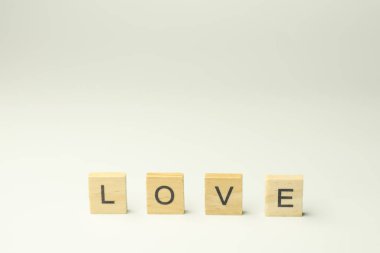 Metin tahta blokları beyaz arkaplanda aşk kelimesini heceliyor