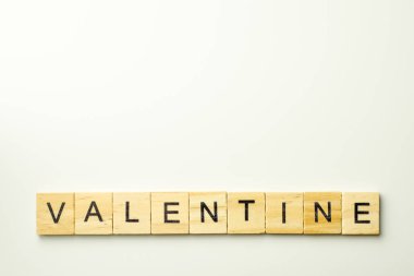 Beyaz arkaplanda Valentine kelimesini heceleyen tahta bloklar