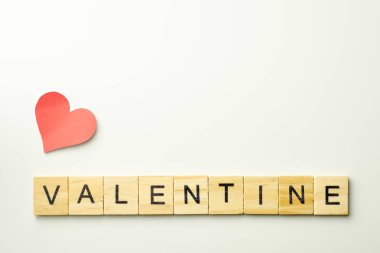 Beyaz arkaplanda Valentine kelimesini heceleyen tahta bloklar