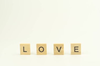 Metin tahta blokları beyaz arkaplanda aşk kelimesini heceliyor