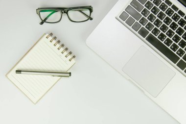 Üzerinde bir sürü şey olan beyaz ofis masası. Kopyalama alanı olan üst görünüm.