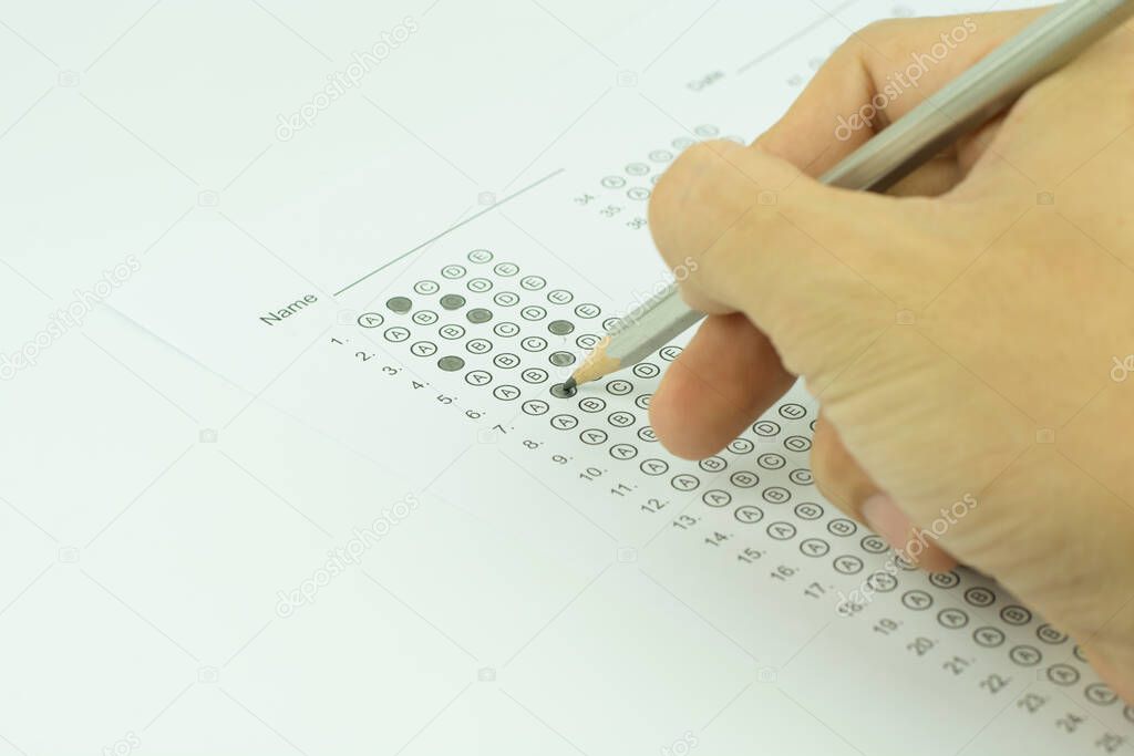 man hands filling in standardized test form