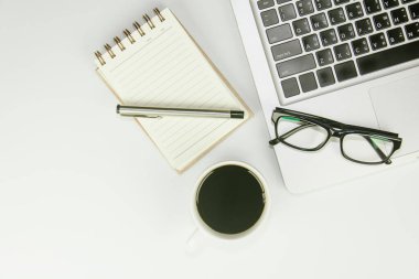 Üzerinde bir sürü şey olan beyaz ofis masası. Kopyalama alanı olan üst görünüm.
