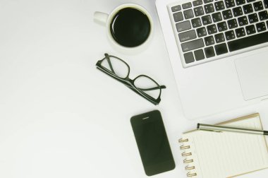 Üzerinde bir sürü şey olan beyaz ofis masası. Kopyalama alanı olan üst görünüm.