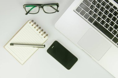 Üzerinde bir sürü şey olan beyaz ofis masası. Kopyalama alanı olan üst görünüm.