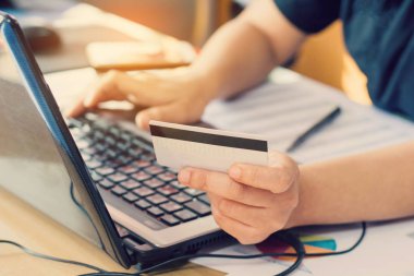 Bilgisayarda klavye yazan ve elinde online alışveriş kartı tutan kadını kapat. 