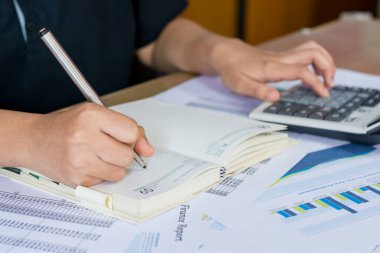 Hesap makinesi ve yazma kullanan kadın elini hesap makinesiyle not et