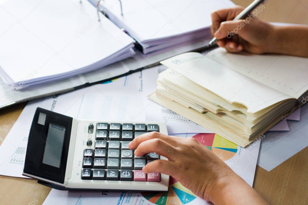 woman hand using calculator and writing make note with calculate