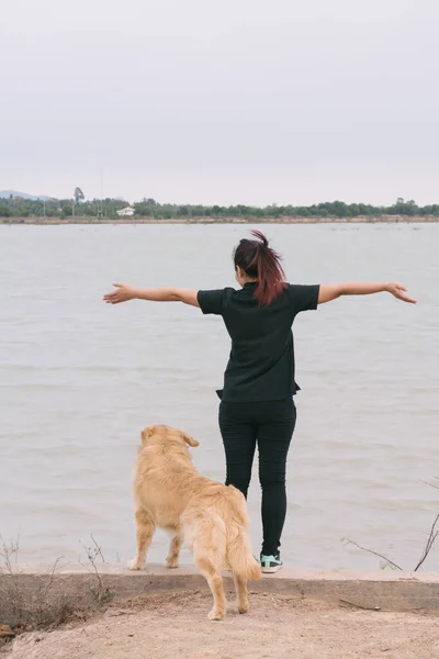 stock image woman and golden dog on riverside