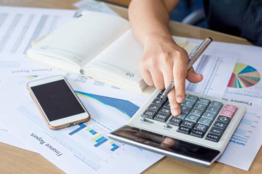 Hesap makinesi ve yazma kullanan kadın elini hesap makinesiyle not et