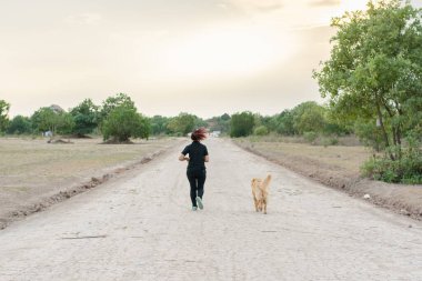 Nehir kenarındaki kadın ve altın köpek