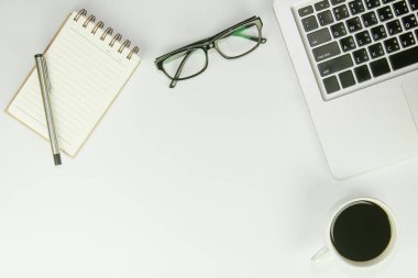 Üzerinde bir sürü şey olan beyaz ofis masası. Kopyalama alanı olan üst görünüm.