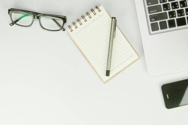 Üzerinde bir sürü şey olan beyaz ofis masası. Kopyalama alanı olan üst görünüm.