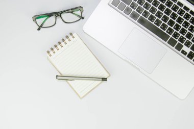 Üzerinde bir sürü şey olan beyaz ofis masası. Kopyalama alanı olan üst görünüm.