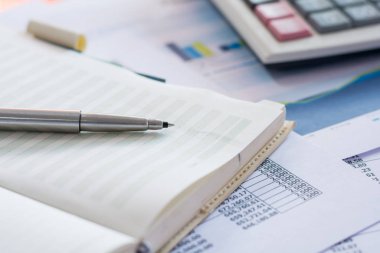 Finans raporundaki kalemi ve masadaki hesap makinesini kapat.