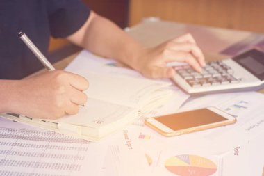 Hesap makinesi ve yazma kullanan kadın elini hesap makinesiyle not et