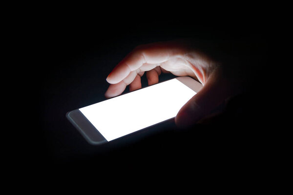 white light from the smartphone reflect your hand at night in the dark.blank screen for text and design