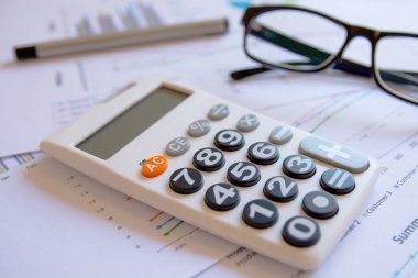 Ofis kavramları: hesap makinesi, gözlük ve kalemle analiz edilen veriler. Sonuçları bulmak için grafiklerden ve grafiklerden.